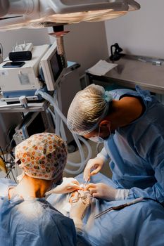 Blepharoplasty plastic surgery operation for modifying the eye region of the face in medical clinic. Surgeon makes an incision with a surgical knife