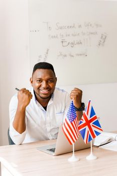 Black handsome man uses his laptop for online work according social distancing. Speaking by web camera with colleagues. Scientist works at home