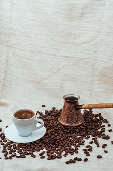 Coffee turk and cup of coffee on burlap background. coffee beans isolated on white background. roasted coffee beans