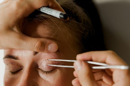 Blepharoplasty markup close-up on the face before the plastic surgery operation for modifying the eye region of the face in medical clinic. 2 doctors do plastic cosmetic operation