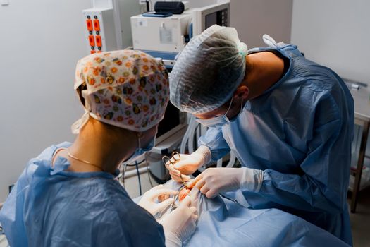 Blepharoplasty plastic surgery operation for modifying the eye region of the face in medical clinic. Surgeon makes an incision with a surgical knife