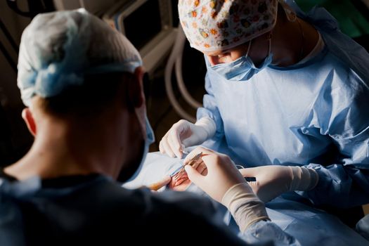 Blepharoplasty plastic surgery operation for modifying the eye region of the face in medical clinic. Surgeon sutures the eyelid