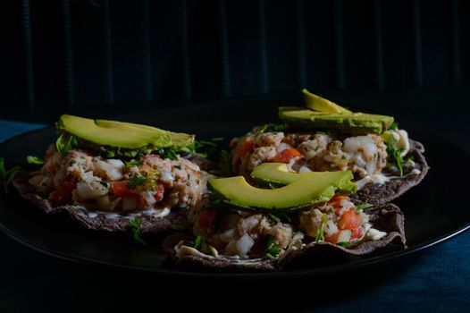 Fish ceviche on blue corn tostadas. Mexican food. Seviche made with tilapia, white fish, onion, tomato, cilantro served on tostadas with mayonnaise