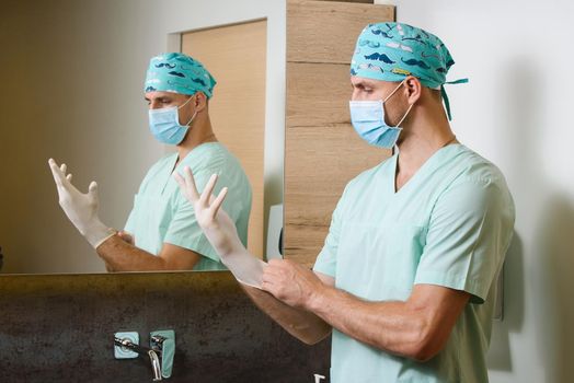 Doctor puts sterile medical gloves on his hands to protect against a pandemic of coronavirus covid 19 in Italy. Hygiene for hands