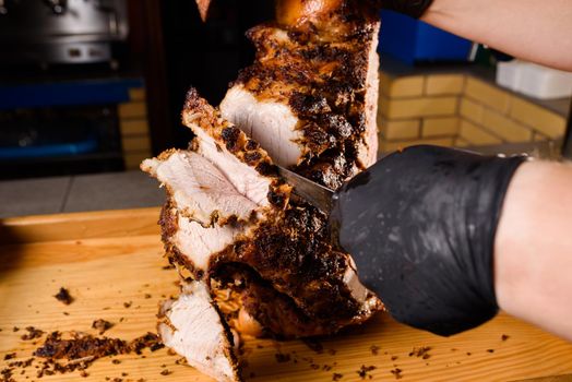 Fried pork cut with a knife. Big peace of pork meat. Cutting meat. Chef cut pork with knife. Advert for meat menu for restaurant