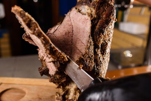 Fried pork cut with a knife. Big peace of pork meat. Cutting meat. Chef cut pork with knife. Advert for meat menu for restaurant