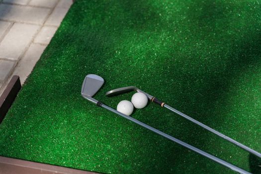 2 Niblick and 2 balls on the green grass for golf sport game.