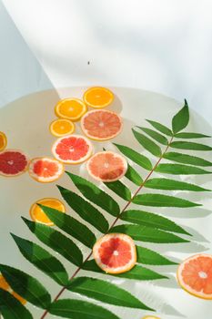 Orange, lemon fruits in the water with green leaves. Decoration for party, Citrus fruits in the bath at hot summer day. Fruits for cocktail
