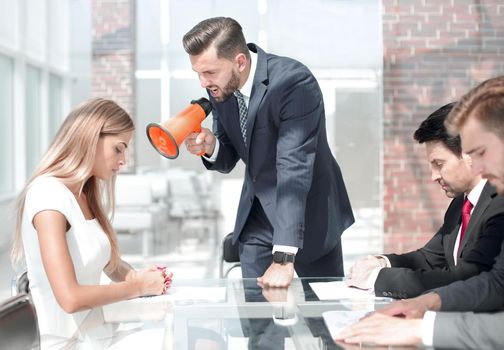 businessman yelling at a female employee through a megaphone . management concept
