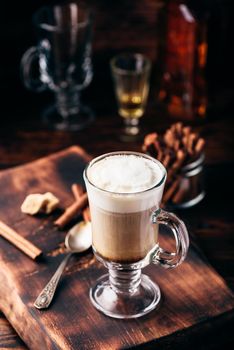 Irish coffee with cinnamon on wooden surface