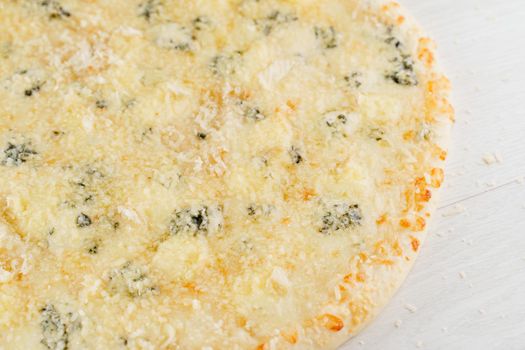 Pizza with cheese such as parmesan, hard cheese, dor blue and mozzarella isolated on white wooden background. Advert for social network of restaurants, caffee