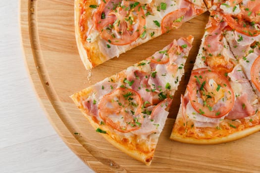 Piece of pizza close-up on the wooden desk. Advert for pezzeria caffee and restaurant. Food delivery at quarantine covid-19 concept.