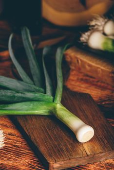 Fresh green leek on wooden cutting board