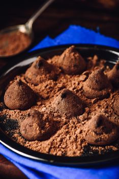 Homemade truffles with dark chocolate on metal tray