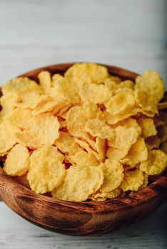 Breakfast cornflakes in a wooden rustic bowl