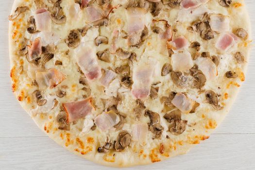 Pizza with bacon, mushrooms and cheese isolated on white wooden background. Advert for social network of restaurants, caffee. Promotion for pizzeria