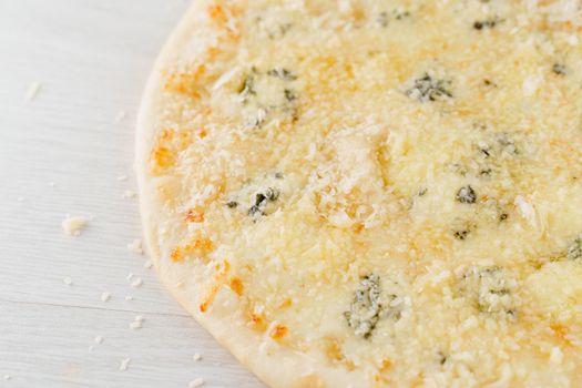 Pizza with cheese such as parmesan, hard cheese, dor blue and mozzarella isolated on white wooden background. Advert for social network of restaurants, caffee