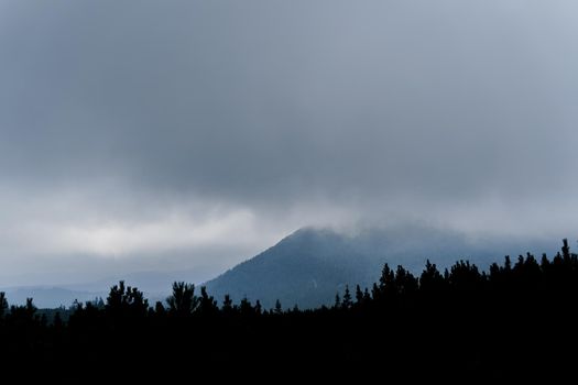 Dusk in the mountains before a storm and a thunderstorm on a rainy and foggy day. Severe weather conditions. Peaks of the Carpathian Mountains
