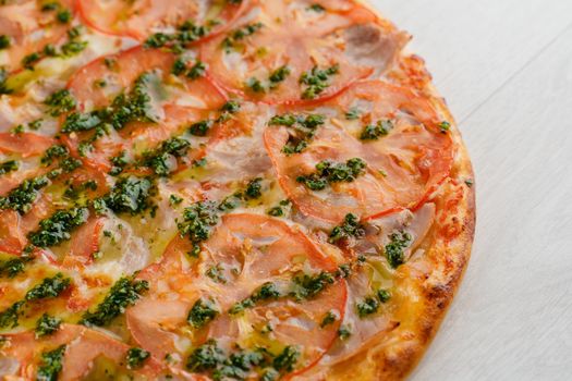 Pizza with tomatoes, cheese, meat, basil sauce isolated on white wooden background. Advert for social network of restaurants, caffee. Promotion for pizzeria