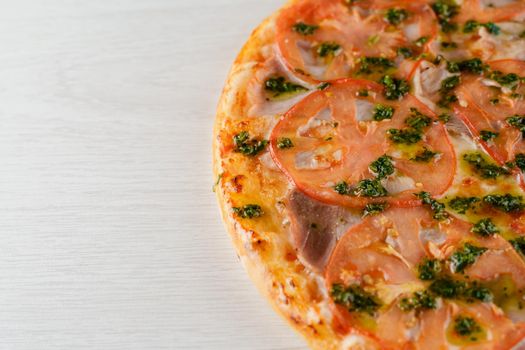 Pizza close-up on white wooden background. Food delivery for people who stay at home. Tasty fast food at quarantine coronavirus covid-19 period.