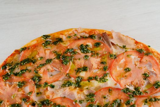 Pizza with tomatoes, cheese, meat, basil sauce isolated on white wooden background. Advert for social network of restaurants, caffee. Promotion for pizzeria