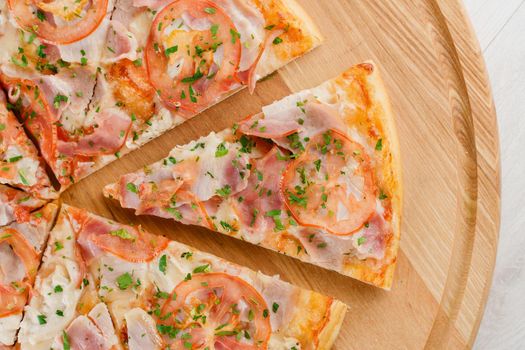 Piece of pizza close-up on the wooden desk. Advert for pizzeria caffee and restaurant. Food delivery at quarantine covid-19 concept.