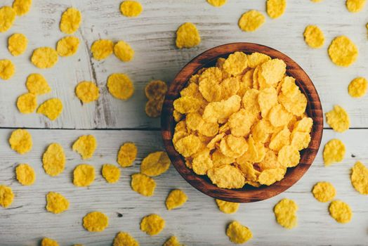 Rustic bowl of cornflakes over wooden surface. View from above