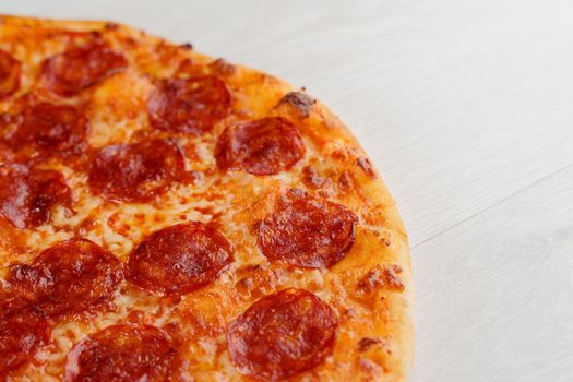Peperoni pizza with salami, cheese and sauce isolated on white wooden background. Advert for social network of restaurants, caffee. Promotion for pizzeria