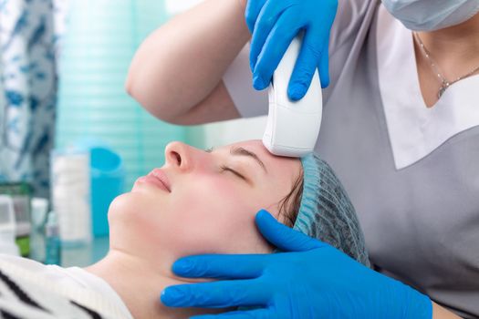 Young woman receiving electric galvanic anti-aging face spa massage at beauty salon. Galvanic massage helps to speed up metabolism, improve regeneration and restore skin protection from harmful external factors.