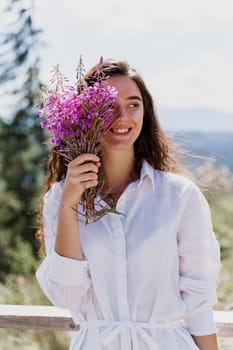 Smiling girl with flowers. Portrait of girl with bouquet in the forest. Tourism