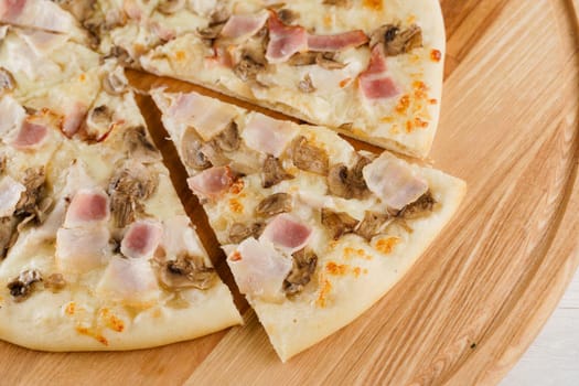 Pizza close-up on white wooden background. Food delivery for people who stay at home. Tasty fast food at quarantine coronavirus covid-19 period.