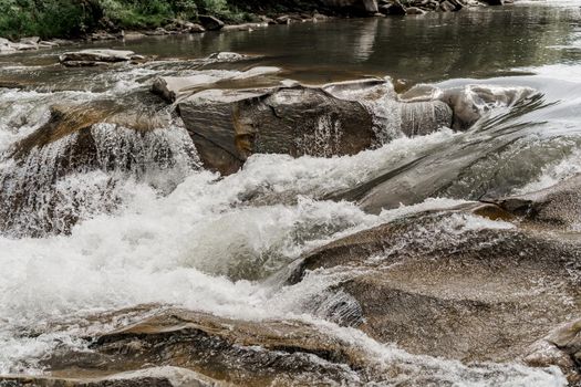 Waterfall in the mountain river with big rocks. Travelling in quarantine period. Nature landscape. Karpathians mountains.