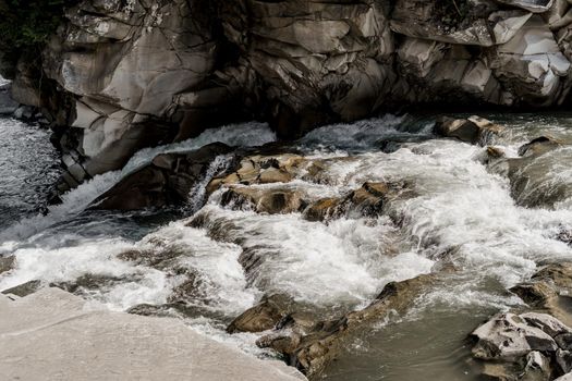 Waterfall in the mountain river with big rocks. Travelling in quarantine period. Nature landscape. Karpathians mountains.