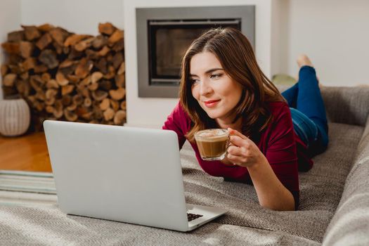 Beautiful woman at home working while drinking one capuchino