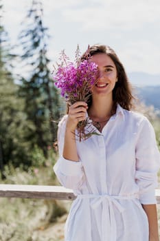Smiling girl with flowers. Portrait of girl with bouquet in the forest. Tourism