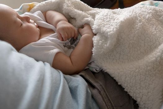 Latin Baby and tired is sleeping in daddy arms. Lifestyle high quality photo horizontal