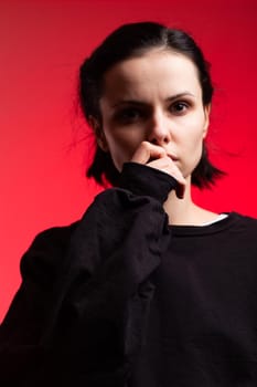 brunette woman in black clothes on red background. High quality photo