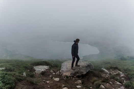 Men tourist is travelling and walking to the peak of mountain. Hiking and climbing up to the top of the mountain. Tourism in Ukraine.