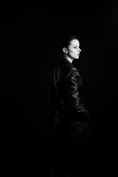 woman with closed eyes in leather coat and, black background. High quality photo