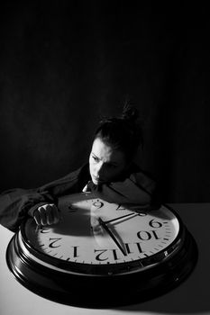 sad woman with big clock, black background. High quality photo