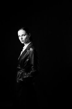 woman with closed eyes in leather coat and, black background. High quality photo