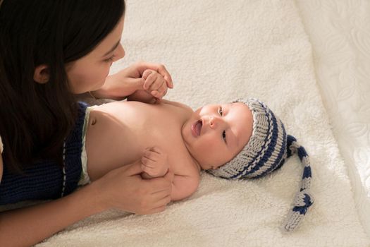 Latin young mother love play happy with baby hands on the bed at home. High quality photo horizontal photo style life