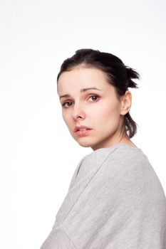 emotional woman in a gray sweatshirt, white background. High quality photo