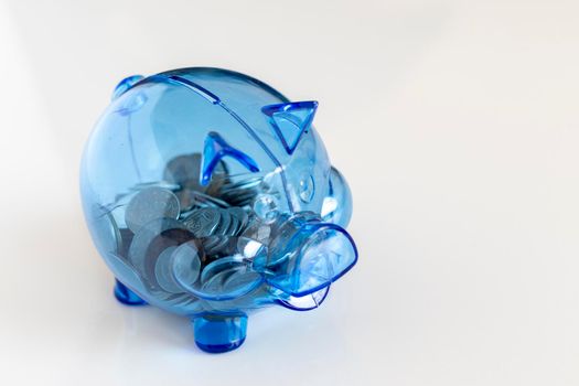 piggy bank full of coins on white isolated background