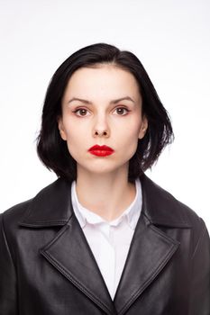 brunette woman with red lipstick on her lips in a black leather jacket and white shirt, white background. High quality photo