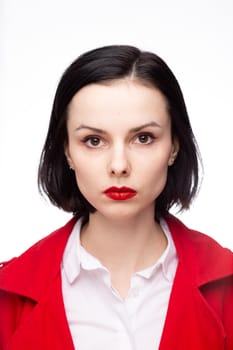 brunette woman with red lipstick on her lips in a red jacket and white shirt, white background. High quality photo