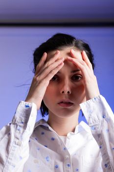 brunette woman in a white shirt with polka dots, on a blue background. High quality photo