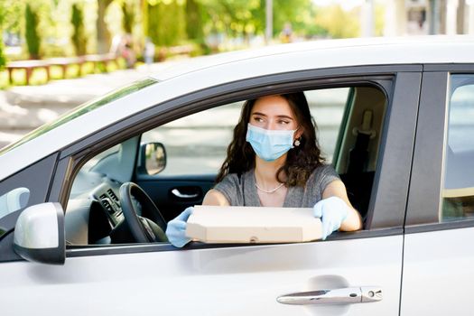 Safe food delivery from pizzeria to car during quarantine covid-19. Delivering food by car according social distance