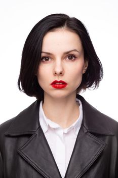brunette woman with red lipstick on her lips in a black leather jacket and white shirt, white background. High quality photo