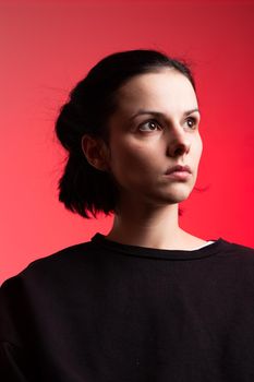 brunette woman in black clothes on red background. High quality photo